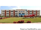 The image shows a large, modern building with a red and white color scheme. The building appears to be a hotel or a conferenc...