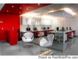 The image shows a modern office space with a red and white color scheme. The room has a high ceiling with recessed lighting a...