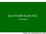 The image is a green square with the text "Matthew Bain Inc. Fine Watches" written in white capital letters. Below the text,...