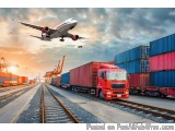 The image shows a red truck with a large container on the back of it, traveling on a railway track. The truck is carrying mul...