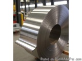 The image shows a roll of steel coils in a factory. The coils are made of aluminum and have a shiny, reflective surface. The...