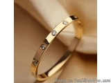 The image is a close-up of a gold bangle bracelet. The bracelet has a thin, curved design with small, round diamonds embedded...