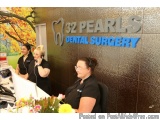 The image shows the interior of a dental clinic called 32 Pearls Dental Surgery. The clinic has a modern and sleek design wit...