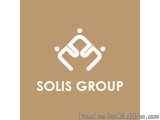 The image is a logo for a company called SOLIS GROUP. The logo is a simple design with a light brown background. In the cente...