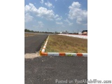 The image shows an empty parking lot with a white and orange striped barrier on the right side. The barrier is made of concre...