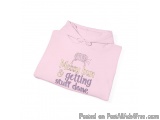 The image is of a pink hoodie with a drawstring hood. On the front of the hoodie, there is a text that reads "Messy bun & get...