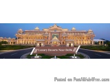 The image is a photograph of a luxurious resort located near Delhi, India. The resort is a large, ornate building with multip...
