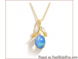 The image is of a gold necklace with a pendant. The pendant is in the shape of a leaf with a blue opal in the center. The opa...