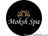 The image is a logo for a spa called Moksh Spa. The logo is circular in shape and has a black background. In the center of th...