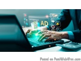 The image shows a person's hands typing on a laptop with the word "AD" on the screen. The laptop is placed on a desk with a c...