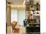 The image shows a modern living room with a large window on the left side. The window has sheer white curtains that let in na...
