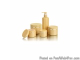 The image shows a set of five cosmetic products in a golden color. There are four jars and a pump dispenser in the image. The...