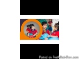 The image is a collage of two photos. The first photo is a close-up of a young boy and a girl sitting on a blue couch. They a...